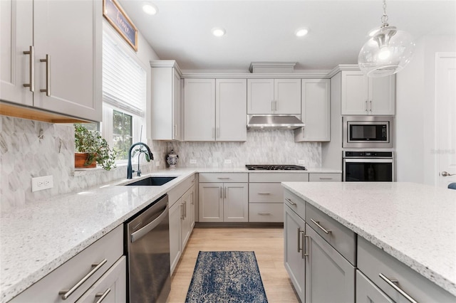 412 S Albany Ave Unit 2, Tampa, FL 33606 - kitchen featuring stainless steel appliances, a sink, light wood-style floors, under cabinet range hood, and light stone countertops