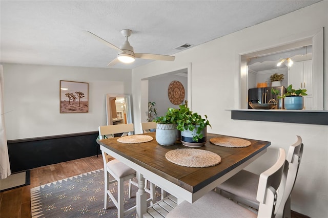 dining space with wood finished floors and ceiling fan