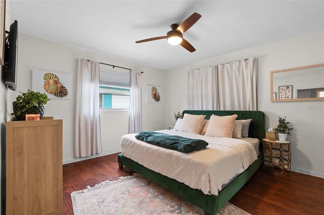 bedroom with hardwood / wood-style floors, a ceiling fan, and baseboards