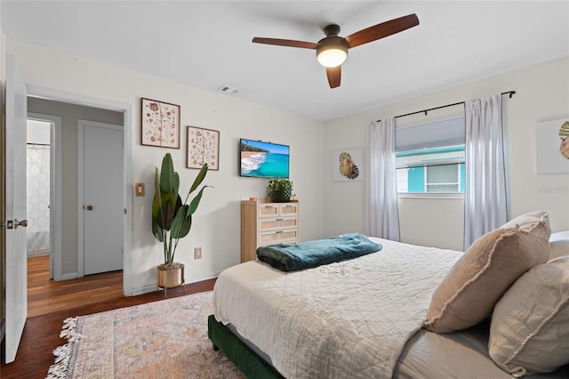 bedroom featuring wood finished floors, baseboards, and a ceiling fan