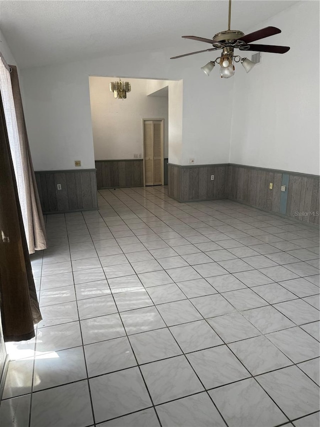 2026 Aaron Pl, Clearwater, FL 33760 - spare room with a wainscoted wall, ceiling fan, wood walls, and vaulted ceiling