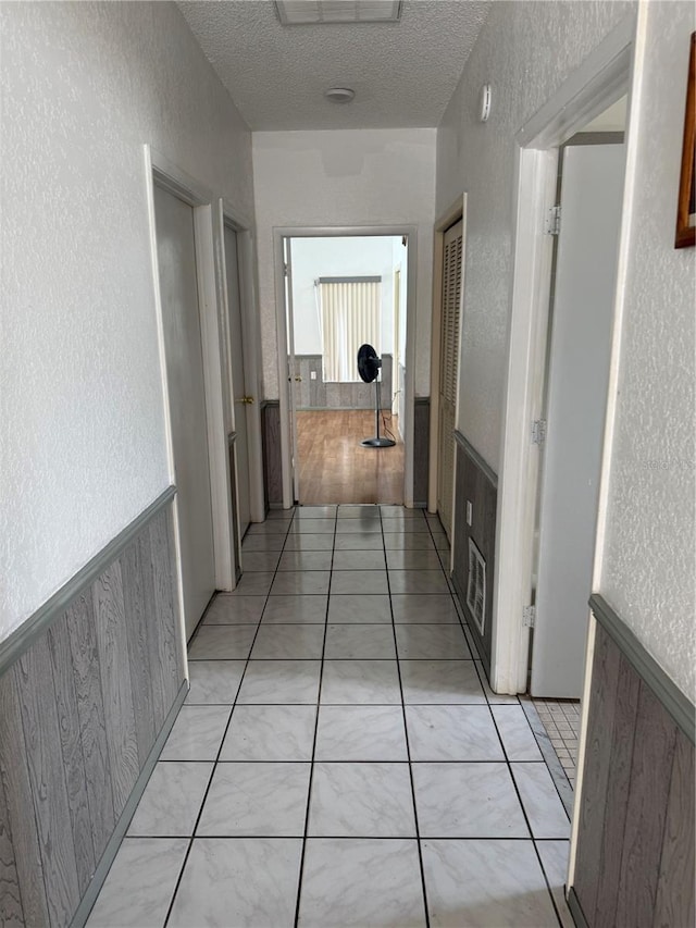2026 Aaron Pl, Clearwater, FL 33760 - corridor with a textured wall, a textured ceiling, and light tile patterned floors