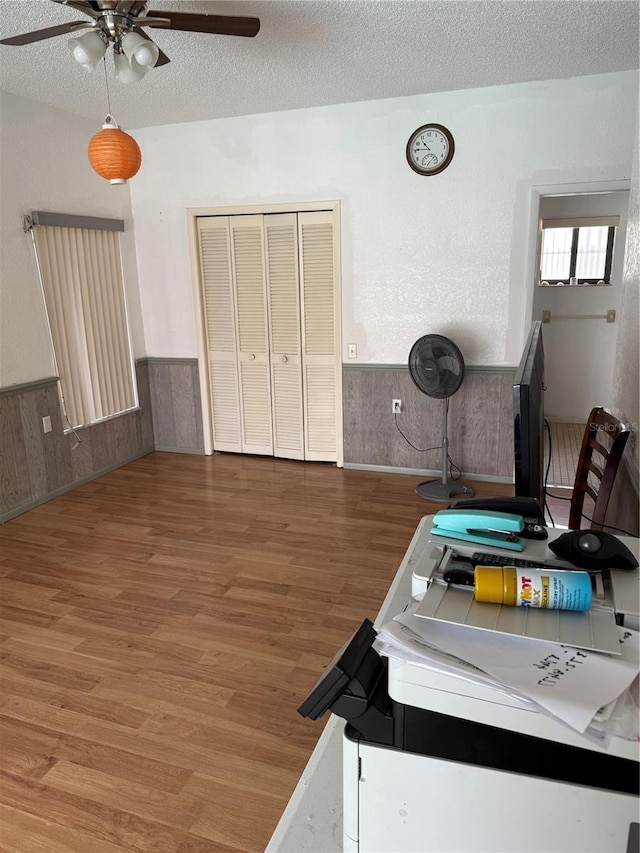 2026 Aaron Pl, Clearwater, FL 33760 - dining space with ceiling fan, a wainscoted wall, wood finished floors, a textured ceiling, and wood walls