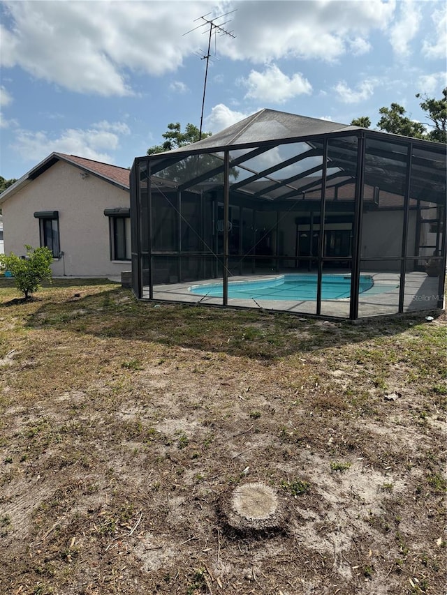 2026 Aaron Pl, Clearwater, FL 33760 - back of property featuring an outdoor pool, stucco siding, and glass enclosure