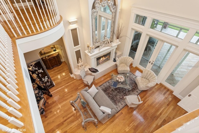 919 Ballinger Rd, Lutz, FL 33548 - living room with wood finished floors, a towering ceiling, a premium fireplace, french doors, and arched walkways