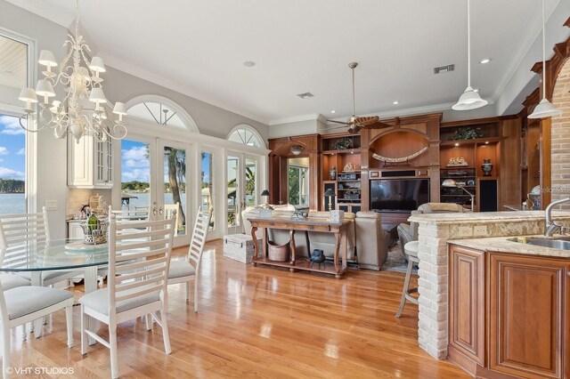 919 Ballinger Rd, Lutz, FL 33548 - dining space with light wood-style floors, ornamental molding, french doors, a chandelier, and recessed lighting
