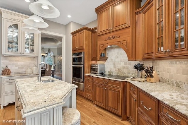919 Ballinger Rd, Lutz, FL 33548 - kitchen featuring black electric stovetop, a warming drawer, brown cabinetry, light stone countertops, and backsplash