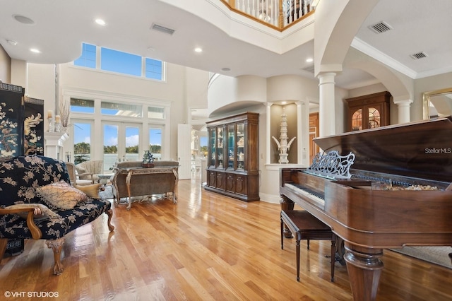 919 Ballinger Rd, Lutz, FL 33548 - sitting room with a high ceiling, ornate columns, light wood-style floors, ornamental molding, and arched walkways