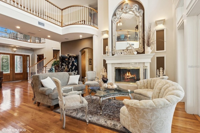 919 Ballinger Rd, Lutz, FL 33548 - living area featuring a towering ceiling, a tile fireplace, wood finished floors, stairs, and arched walkways