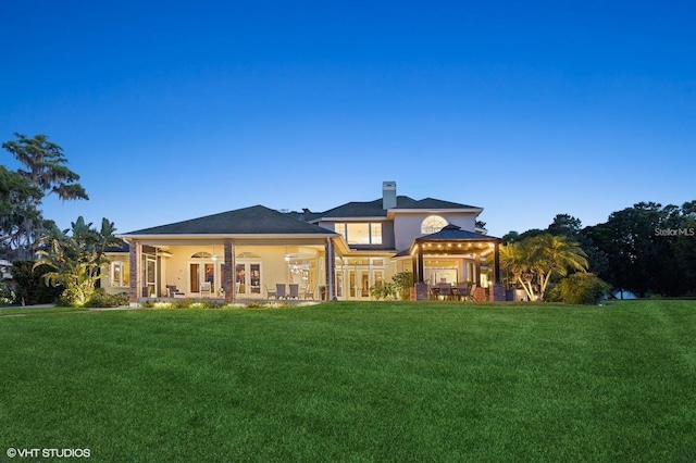 919 Ballinger Rd, Lutz, FL 33548 - rear view of property featuring a yard, french doors, a chimney, and stucco siding