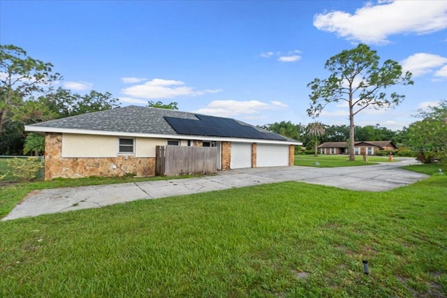 903 Tomahawk Trl, Brandon, FL 33511 - view of front of home with roof mounted solar panels, stone siding, driveway, and an attached garage