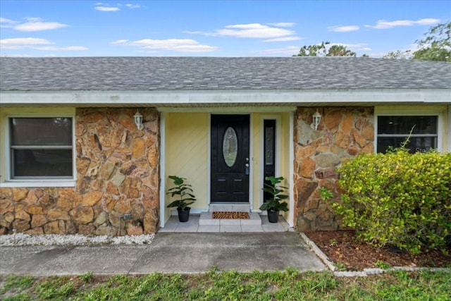 903 Tomahawk Trl, Brandon, FL 33511 - view of exterior entry featuring stone siding and a shingled roof