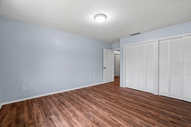 903 Tomahawk Trl, Brandon, FL 33511 - unfurnished bedroom featuring wood finished floors, two closets, and baseboards