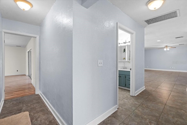 903 Tomahawk Trl, Brandon, FL 33511 - corridor with tile patterned floors, baseboards, a textured wall, and a sink