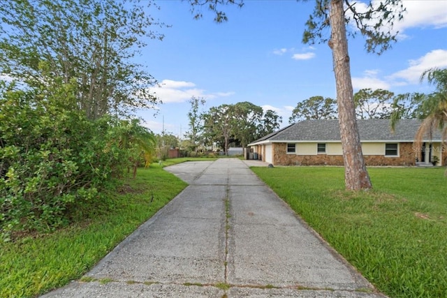 903 Tomahawk Trl, Brandon, FL 33511 - view of front of home featuring concrete driveway, stone siding, and a front lawn