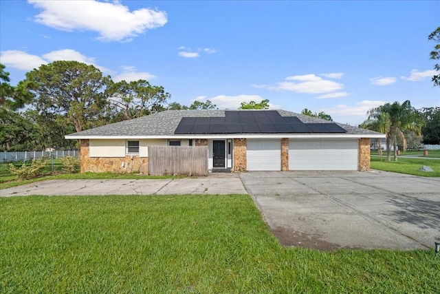 903 Tomahawk Trl, Brandon, FL 33511 - ranch-style house featuring roof mounted solar panels, concrete driveway, an attached garage, and stone siding