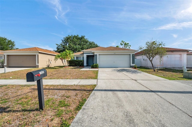 ranch-style home with an attached garage, stucco siding, concrete driveway, and a front yard