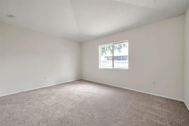 empty room featuring carpet floors, a smoke detector, baseboards, and a textured ceiling