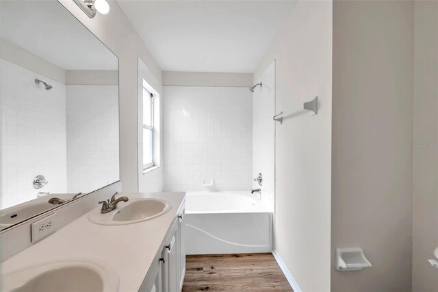 full bath with wood finished floors, bathing tub / shower combination, and double vanity
