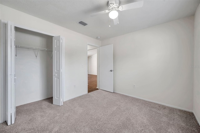 unfurnished bedroom featuring carpet, a closet, and ceiling fan