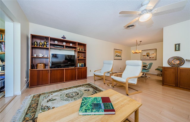 368 Perth Ct Unit 368, Dunedin, FL 34698 - living room featuring light wood-style flooring, ceiling fan, a chandelier, and a textured ceiling