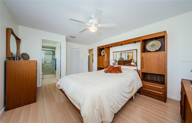 368 Perth Ct Unit 368, Dunedin, FL 34698 - bedroom with light wood finished floors, a textured ceiling, connected bathroom, a ceiling fan, and baseboards