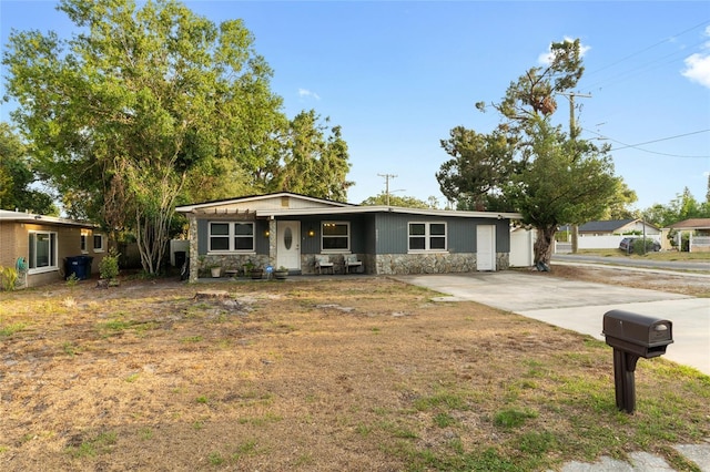 8001 N Ola Ave, Tampa, FL 33604 - view of front facade with stone siding, concrete driveway, and covered porch