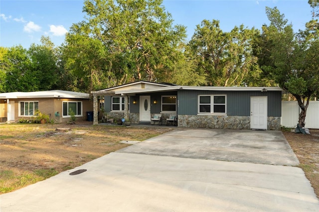 8001 N Ola Ave, Tampa, FL 33604 - view of front of home with stone siding, a porch, concrete driveway, and fence