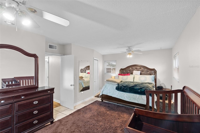 8001 N Ola Ave, Tampa, FL 33604 - bedroom featuring multiple windows, light tile patterned floors, ceiling fan, a textured ceiling, and baseboards