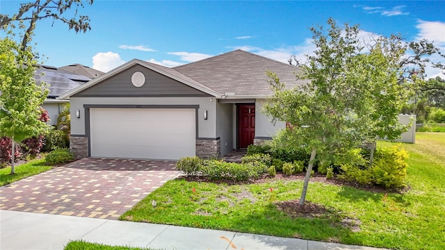 3891 Reflection Dock Dr, Seffner, FL 33584 - ranch-style home featuring stone siding, decorative driveway, a garage, a front yard, and stucco siding