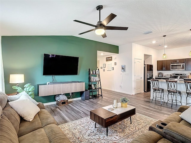3891 Reflection Dock Dr, Seffner, FL 33584 - living area featuring wood finished floors, a ceiling fan, lofted ceiling, baseboards, and recessed lighting