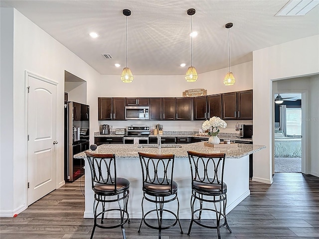 3891 Reflection Dock Dr, Seffner, FL 33584 - kitchen featuring stainless steel appliances, dark brown cabinets, dark wood-style floors, a sink, and recessed lighting