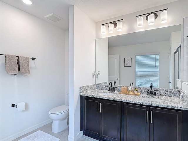 3891 Reflection Dock Dr, Seffner, FL 33584 - bathroom with toilet, tile patterned floors, double vanity, baseboards, and an enclosed shower