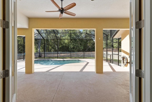 view of pool featuring a patio area, a ceiling fan, and a lanai
