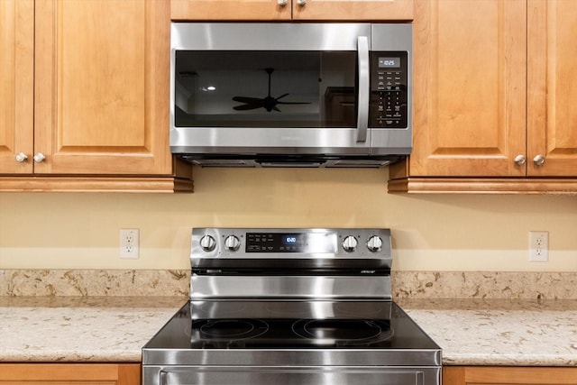 kitchen featuring stainless steel appliances and light stone counters