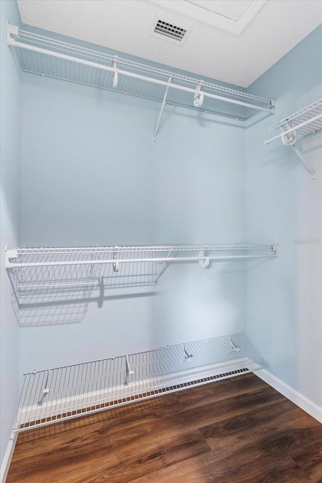 walk in closet with wood finished floors