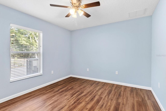 spare room featuring wood finished floors, baseboards, and a ceiling fan