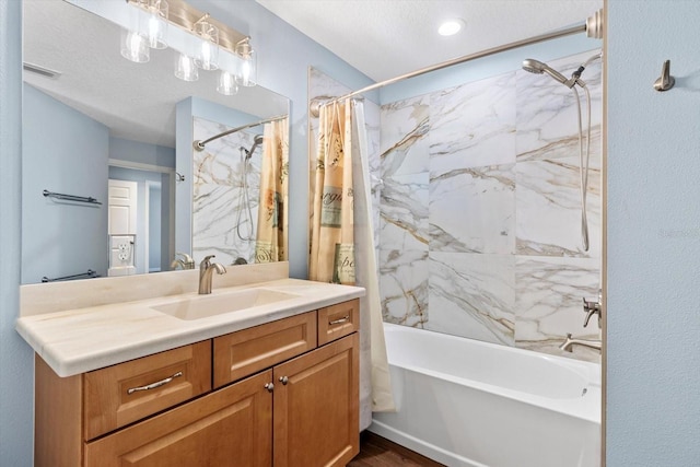 bathroom with shower / bath combo, wood finished floors, vanity, and a textured ceiling