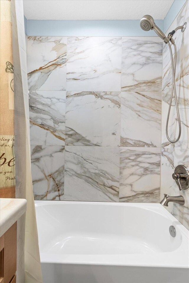 bathroom featuring shower / bath combo and vanity