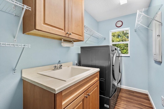 laundry room featuring washer and clothes dryer, cabinet space, dark wood-style floors, and baseboards