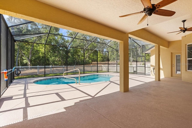view of swimming pool with a patio area, a ceiling fan, glass enclosure, and fence