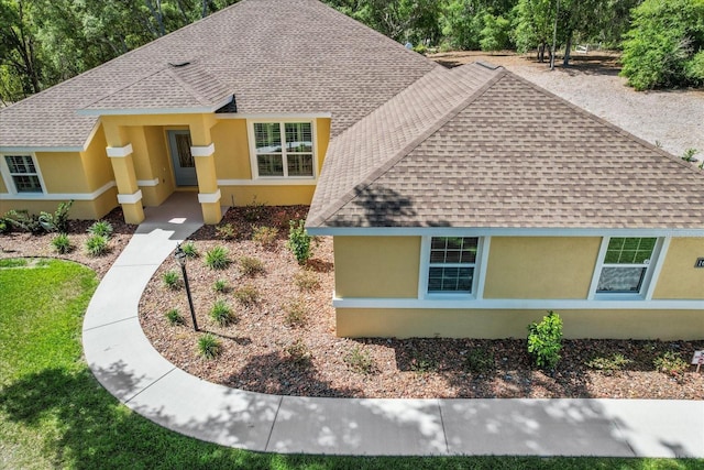 view of front of house featuring roof with shingles and stucco siding