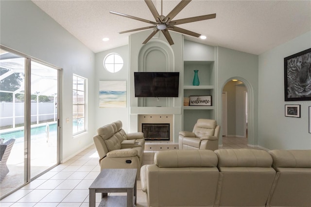 7838 Trail Run Loop, New Port Richey, FL 34653 - living area with lofted ceiling, ceiling fan, built in shelves, light tile patterned floors, and healthy amount of natural light