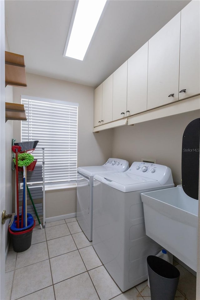 7838 Trail Run Loop, New Port Richey, FL 34653 - laundry area featuring cabinet space, washing machine and dryer, light tile patterned flooring, and baseboards