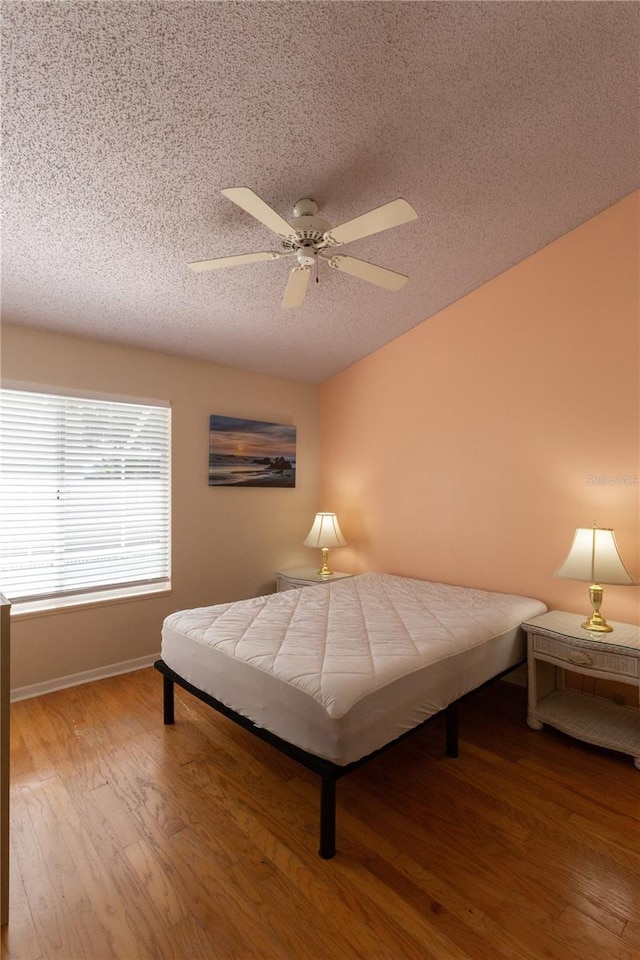7838 Trail Run Loop, New Port Richey, FL 34653 - bedroom featuring a textured ceiling, wood finished floors, baseboards, and ceiling fan