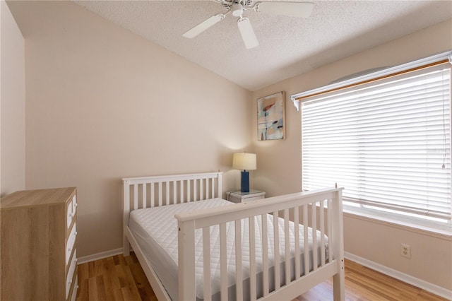 7838 Trail Run Loop, New Port Richey, FL 34653 - bedroom with vaulted ceiling, wood finished floors, baseboards, a textured ceiling, and ceiling fan