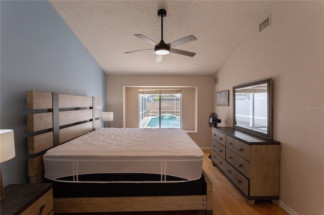 7838 Trail Run Loop, New Port Richey, FL 34653 - bedroom featuring a textured ceiling, light wood finished floors, vaulted ceiling, access to exterior, and ceiling fan