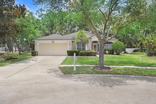 single story home with a garage, concrete driveway, a front yard, and stucco siding