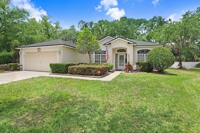 ranch-style home with a garage, driveway, a front yard, and stucco siding