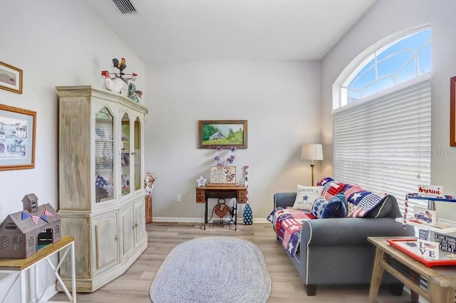 living area with light wood-type flooring and baseboards